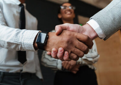 A group of people shaking hands over a table.