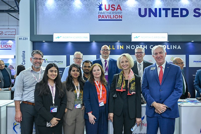 A group of people standing in front of a sign.